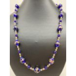 A 22" glass Venetian style beaded necklace in royal blue and gold tones. With gold coloured T bar
