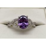 A rhodium plated Swarovski crystal set costume jewellery dress ring. Central oval cut purple crystal