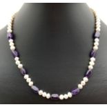 A freshwater pearl and amethyst beaded necklace with silver tone magnetic clasp. Approx. 17".
