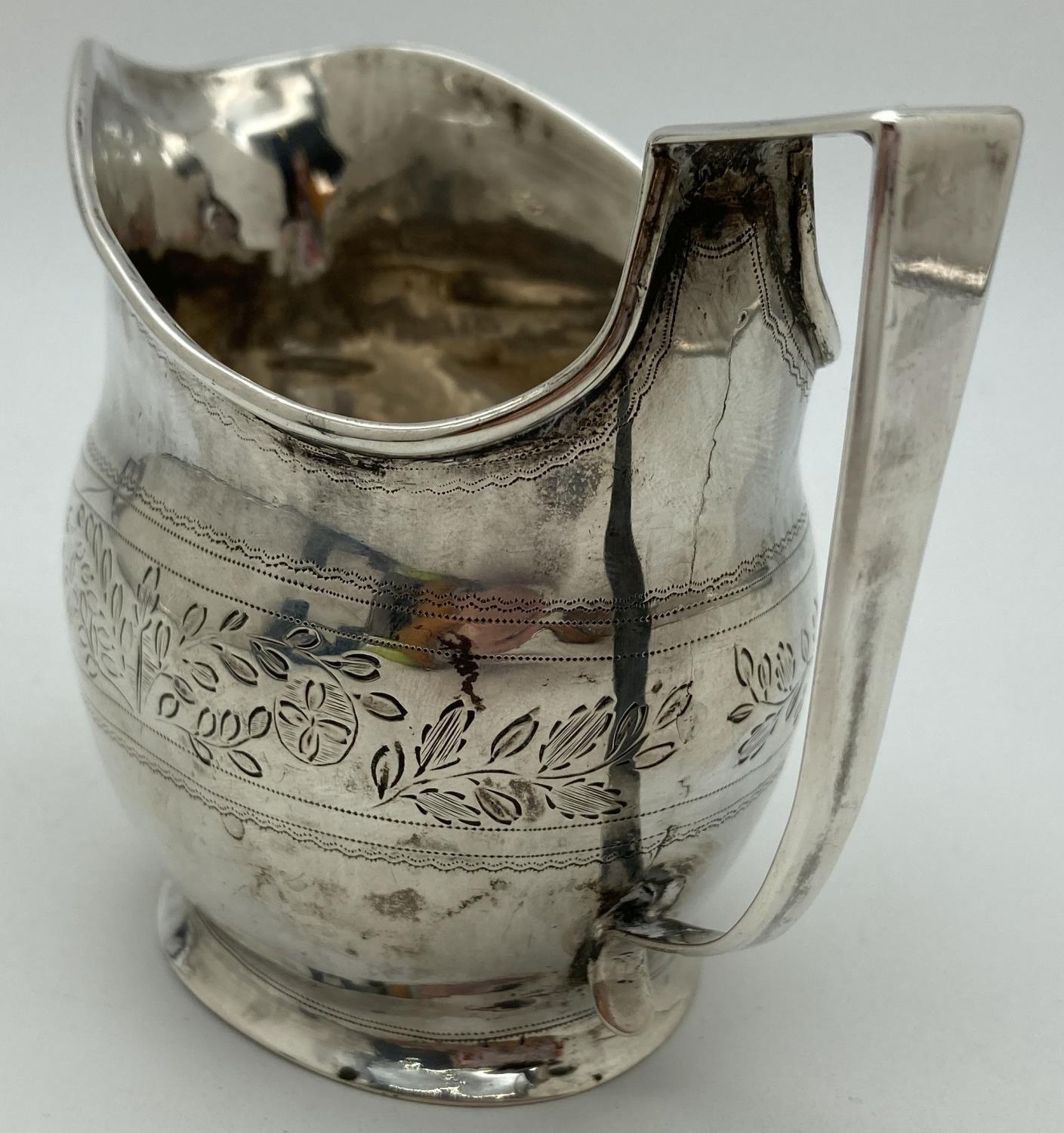 A Georgian silver cream jug with engraved floral banded design. Featuring a wreathed circular shaped - Image 4 of 4