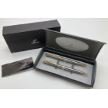 A Parker Insignia propelling pencil and ball point pen set. In brushed silver tone with gold tone