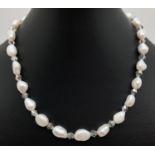 A 16" alternate freshwater pearl and grey crystal bead necklace with white metal T bar clasp.