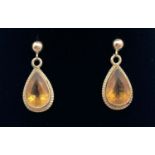 A pair of 9ct gold ball stud earrings with teardrop shaped citrine drops. Set in a 9ct gold (tests