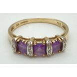A 9ct gold, amethyst & diamond ring set with square cut amethyst stones. Each amethyst interspaced