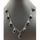 A silver and and faceted teardrop shaped black onyx drop bead necklace with spring clasp. Fixings