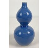 A small Chinese ceramic bottle gourd shaped bud vase with blue glaze. Signature marks to