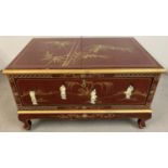 An Oriental design red lacquer small coffee table/ unit with front pull down cupboard and small