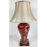 A modern ceramic Mandarin Arts Limited table lamp in deep red glaze with painted peach blossom