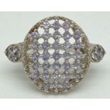 A large silver statement cocktail ring set with 39 small round cut tanzanite stones. Pierced work