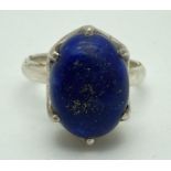 A modern design silver dress ring with high mount set with an oval lapis lazuli cabochon stone.
