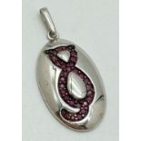 A modern oval shaped silver pendant with cat design to front. Set with 28 round cut rubies. Silver