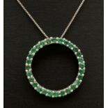 A modern design silver open circular pendant set with 28 round cut emeralds. On an 18 inch fine