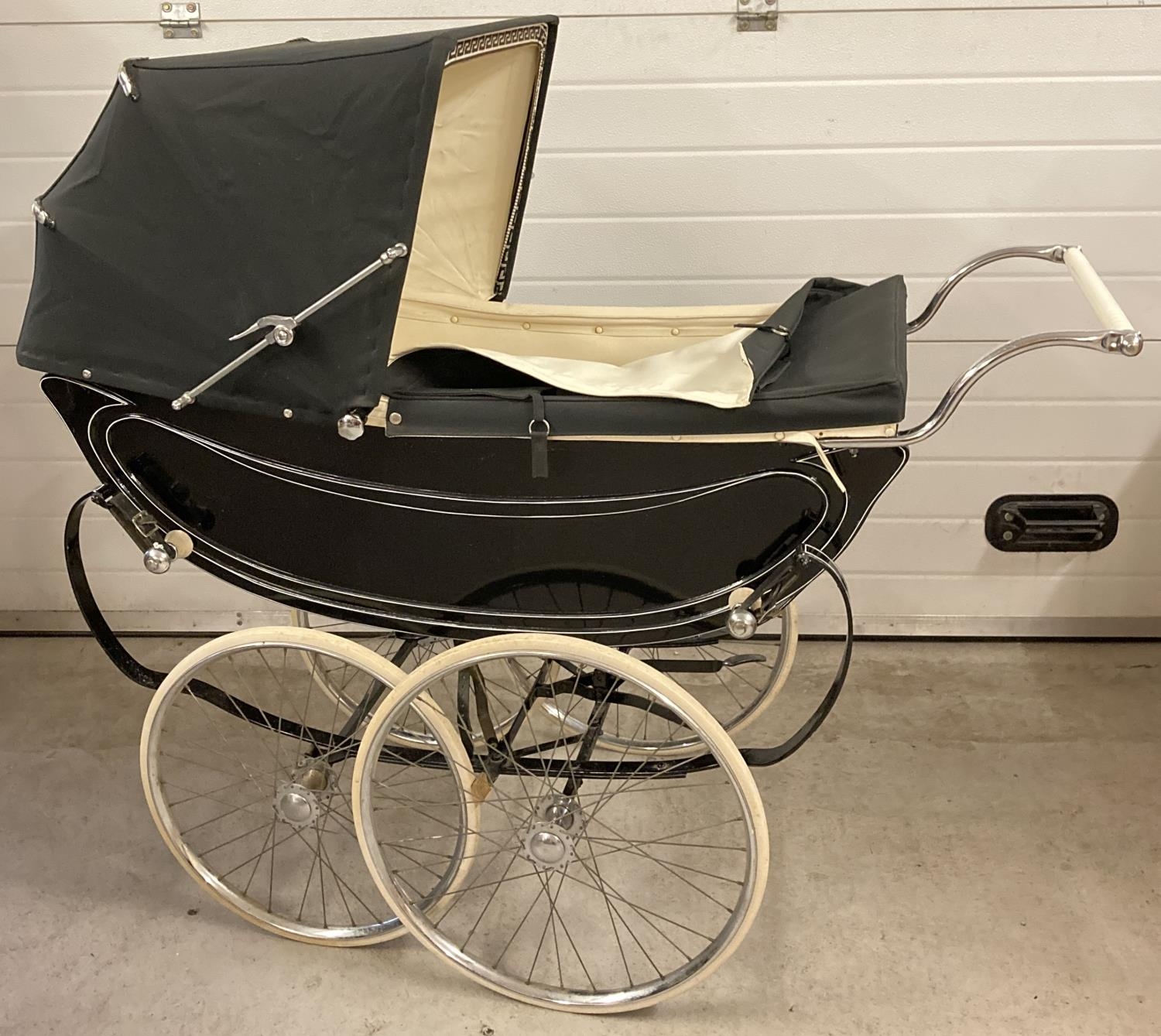 A vintage 1960's Sol Peram coach built pram painted in black & cream. Wooden bodied with cream