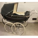 A vintage 1960's Sol Peram coach built pram painted in black & cream. Wooden bodied with cream