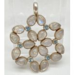 A large modern flower design pendant set with moonstones and blue topaz, by The Genuine Gem Company.