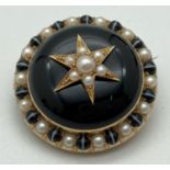 A Victorian gold mourning brooch with black enamelled central panel and set with seed pearls.