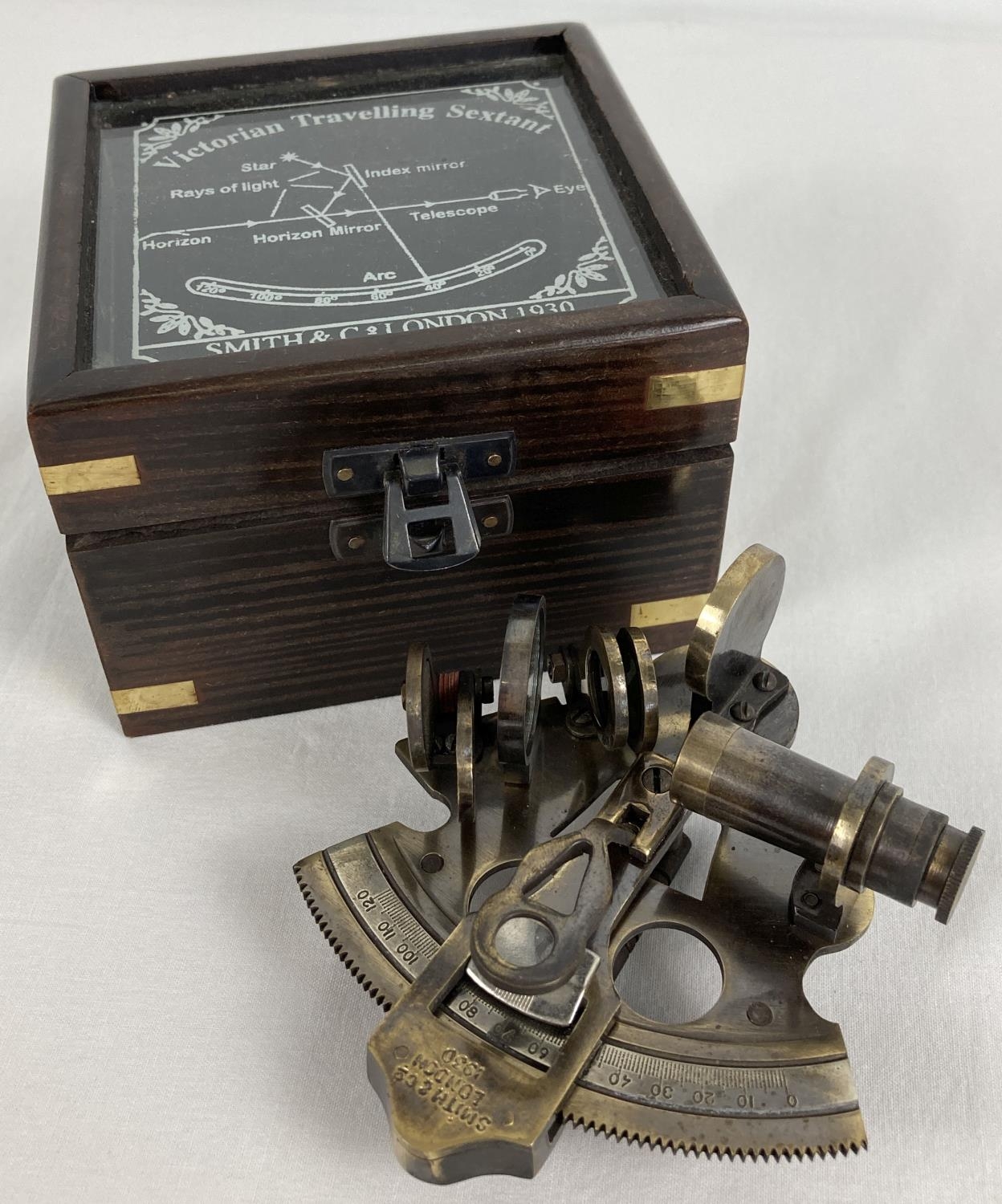 A replica wooden and glass lidded box containing a "Victorian Travelling Sextant" by Smith & Co.