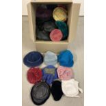 A large box of assorted vintage hats in varying colours and styles.