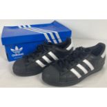 A pair of boxed Adidas Superstar trainers in black & white. With black sole and toe, size 4, in