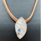 A modern design silver marquise shaped pendant set with white shell and a pale blue faceted stone,
