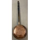 A large vintage copper bed warming pan with decoration to lid and long carved wooden handle. Total
