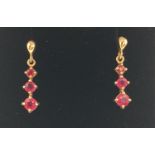A pair of 9ct yellow gold ruby set drop earrings, fully hallmarked to posts. Complete with butterfly