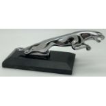 A chrome jaguar figurine screw mounted on a black marble base. Approx. 8.5cm tall x 21cm long.