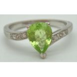 An 18ct white gold, peridot and diamond ring. With central teardrop peridot. In a twist setting with