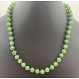 An 18 inch knotted jade bead necklace with lobster style clasp.