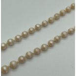 A vintage 18" string of knotted pearls with a 9ct gold fishhook clasp. Clasp fully hallmarked to