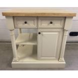 A modern cream painted kitchen island/unit with butcher block top. With undershelf, double sided