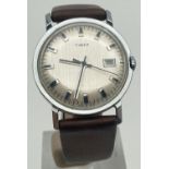 A vintage men's vintage wristwatch by Timex with brown leather strap. Silver tone brushed style face