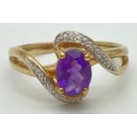 A 9ct gold, amethyst and diamond dress ring with twist style setting. Central oval cut amethyst (