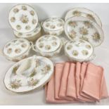 A quantity of modern ceramic dinner ware with peach floral design. Together with a table cloth and