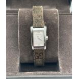 A ladies stainless steel square case 8600L wristwatch by Gucci with classic Gucci logo cloth and