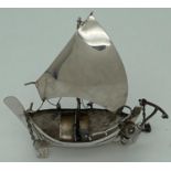 A vintage silver miniature sailing boat figurine with rudder, anchor and bailing bucket. Marked