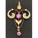 An Art Nouveau 9ct gold pendant set with seed pearls, central purple coloured stone and drop