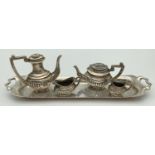 A hallmarked silver 5 piece miniature tea set of classical design. Comprising: water pot (with