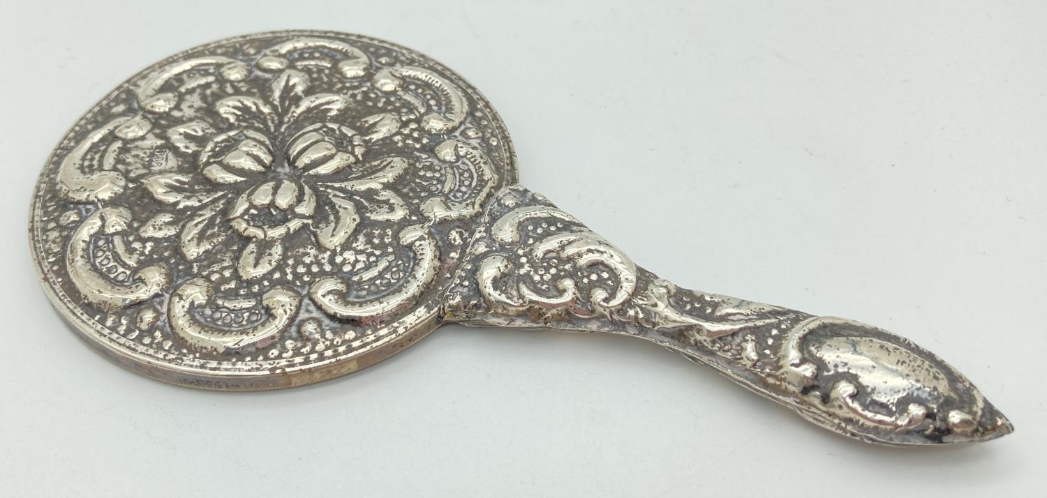 A small hand held 900 silver embossed mirror with scroll and foliate design. Approx. 14.5cm long, - Image 2 of 4