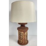 A vintage studio pottery lamp base with impressed circular design. Complete with cream coloured