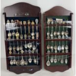 2 wooden wall shelves containing a collection of souvenir & collectable spoons.