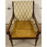 A vintage wooden framed arm chair with turned detail to legs and arms. Back cushion has been