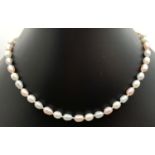 An alternating cream, peach and grey freshwater pearl necklace with 18ct gold clasp. Knotted between