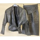 A 1980's black leather batwing jacket skirt suit. unusual crossover design fastening to front of