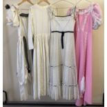 4 vintage theatre costume full length dresses, 3 in white and 1 pink.