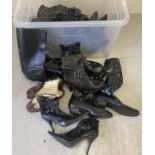 A large tub of vintage and modern women's leather & faux leather boots and shoes. In varying