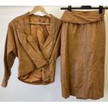 A vintage 1980's tan leather skirt suit with unusual crossover buckle detail. A batwing short jacket