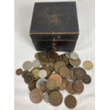 A small vintage wooden box containing a collection of vintage British and foreign coins. To
