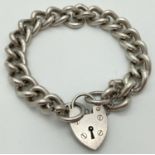 A heavy vintage silver curb chain charm bracelet with padlock clasp and safety chain. Hallmarked