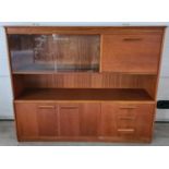 A mid century teak low display unit with glass sliding doors, cupboards and 3 drawers. With integral